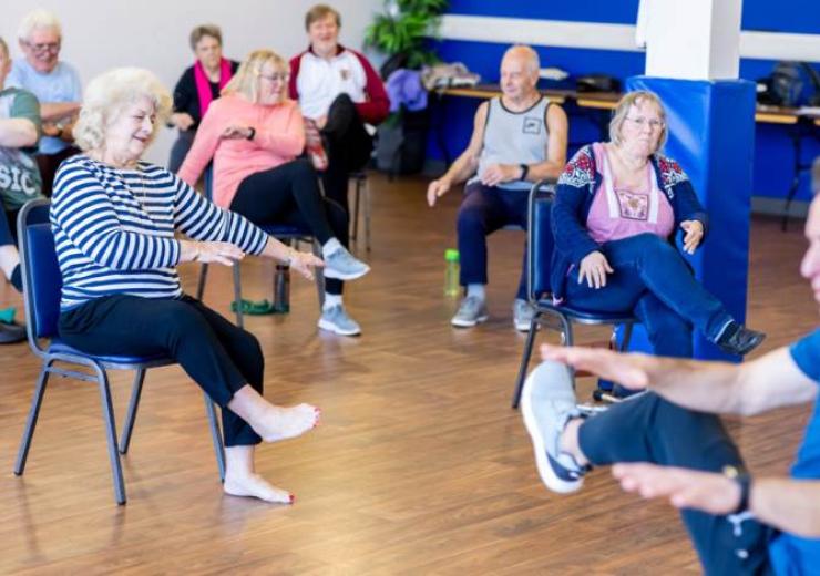 Group of elderly people doing seated exercise